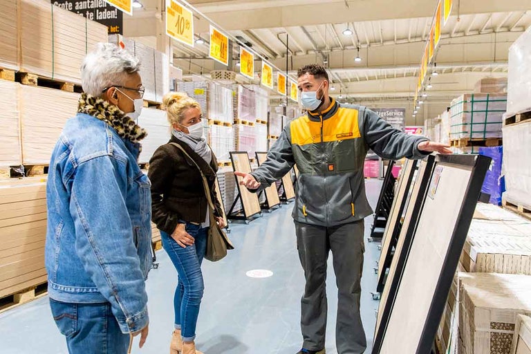 Klanten krijgen advies over tegels van een medewerker in de Hornbach bouwmarkt.