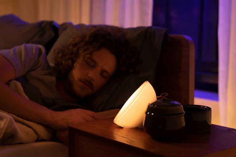 Slapende man met een nachtlampje op een nachtkastje