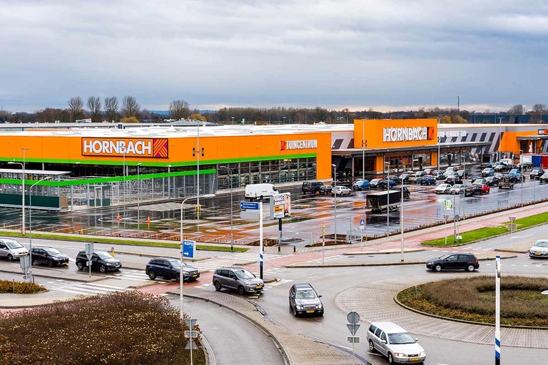 Buitenaanzicht van een Hornbach bouw- en tuinmarkt met parkeerplaats en toegangsweg
