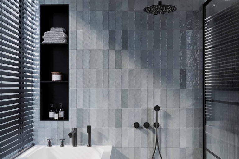 Moderne badkamer met blauwachtig glimmende wandtegels, douchekop, kranen en nissen.