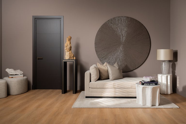 Modern ingerichte kamer met deur, ligbank en decoratie