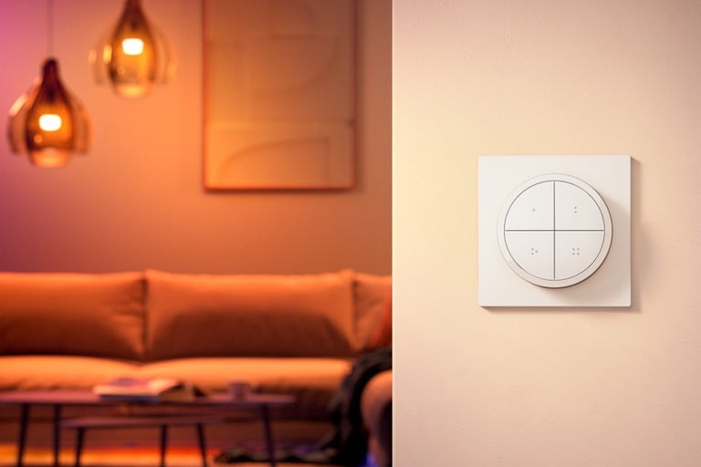 Scène van een woonkamer met een slimme lichtschakelaar aan de muur