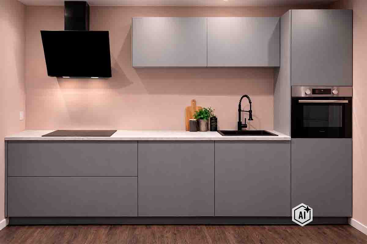Moderne inbouwkeuken met gladde fronten, afzuigkap, inductiekookplaat, spoelbak, kraan en geïntegreerde oven in een strak design.