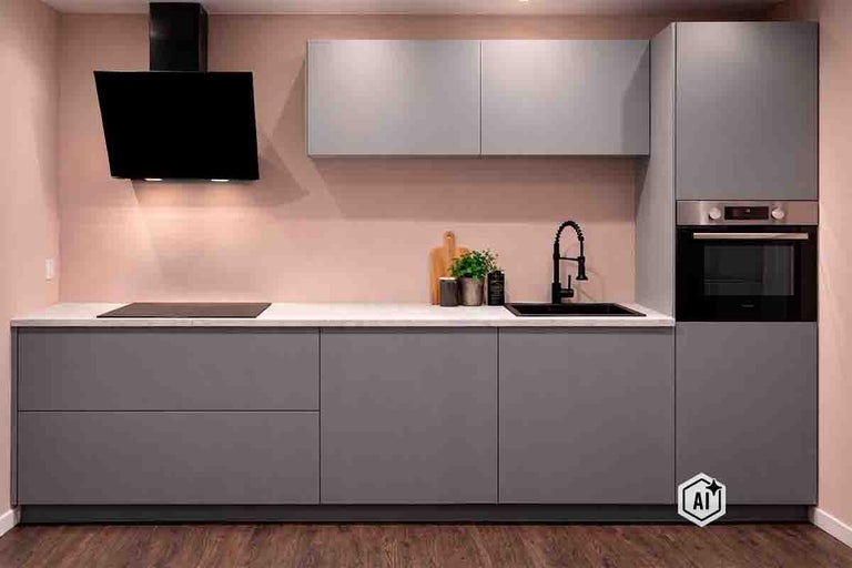 Moderne inbouwkeuken met gladde fronten, afzuigkap, inductiekookplaat, spoelbak, kraan en geĂŻntegreerde oven in een strak design.