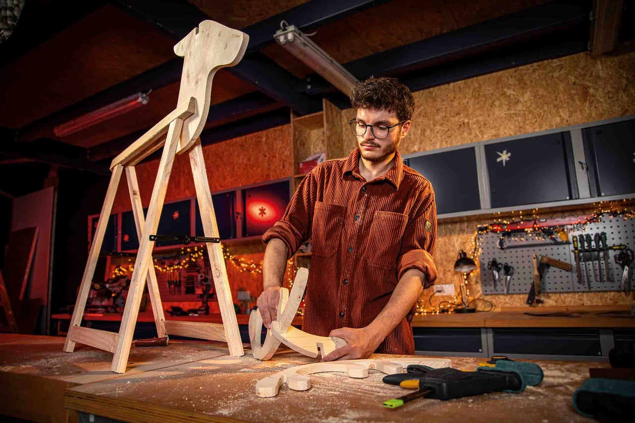 Man bouwt houten hobbelpaard in werkplaats