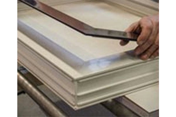 Detailopname van een raamkozijn met een hand die een ruit plaatst