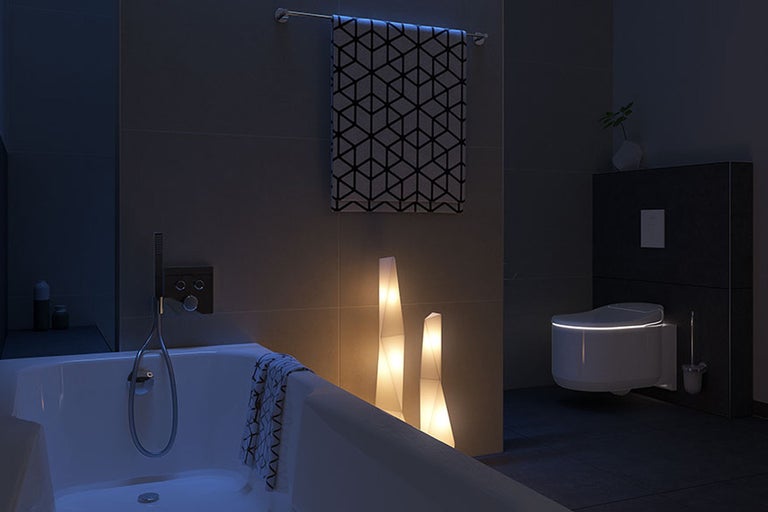 Moderne badkamer met bad, handdoek, lampen en toilet