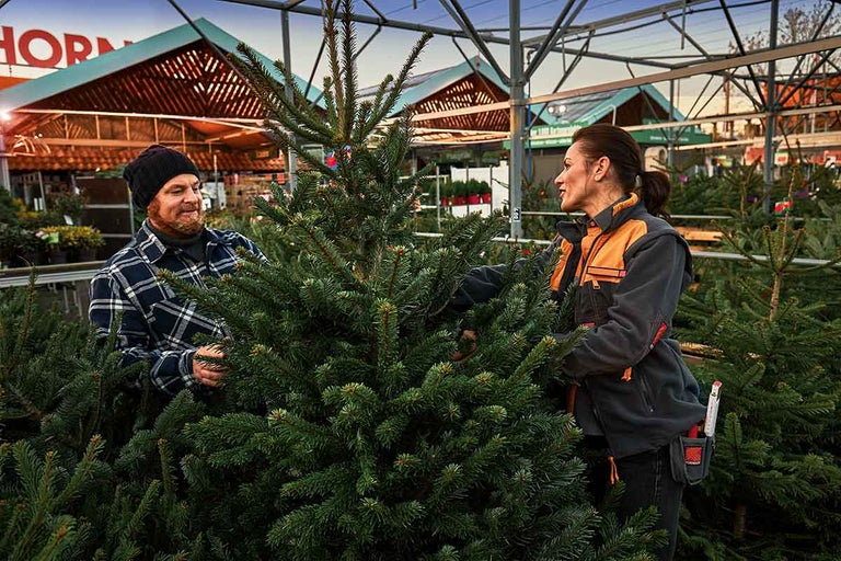Klant en medewerker kiezen samen een kerstboom in de Hornbach vestiging.