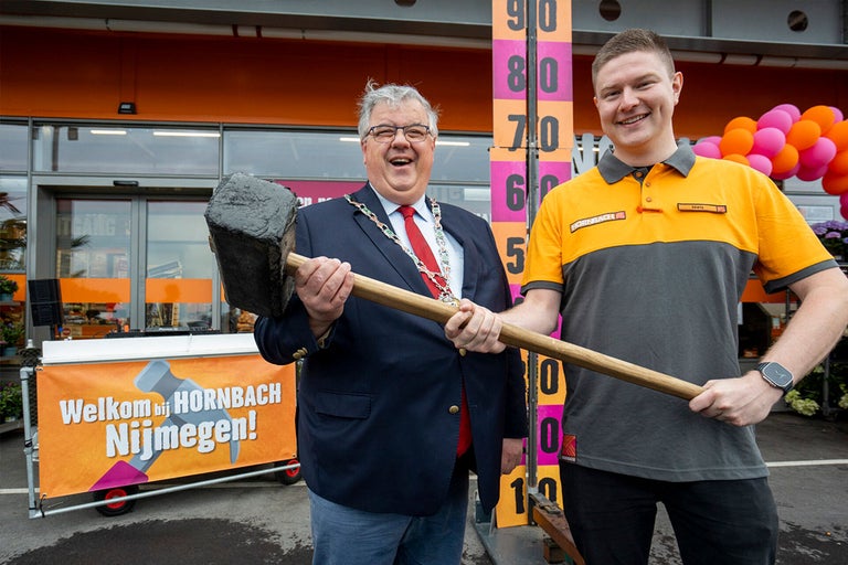 Twee mannen houden een hamer vast voor een Hornbach bouwmarkt.