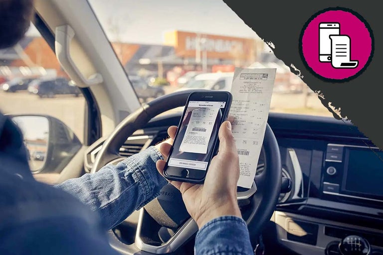 Persoon in auto scant Hornbach kassabon met smartphone.