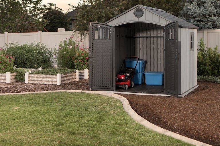 Tuinscene met tuinhuis, grasmaaier en tuingereedschap