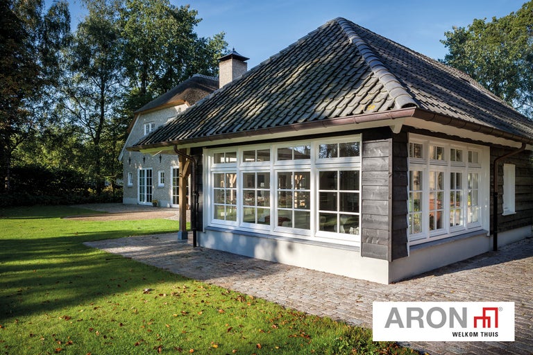 Huis met witte ramen en donkere houten bekleding