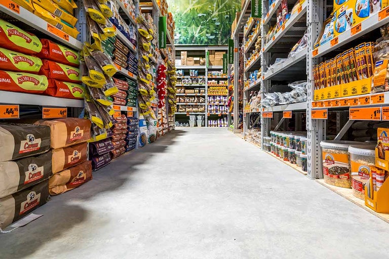 Gang in de bouwmarkt met schappen vol diervoeding