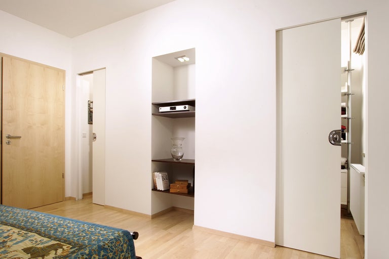 Interieur met houten deur, planken en schuifdeur naar inloopkast