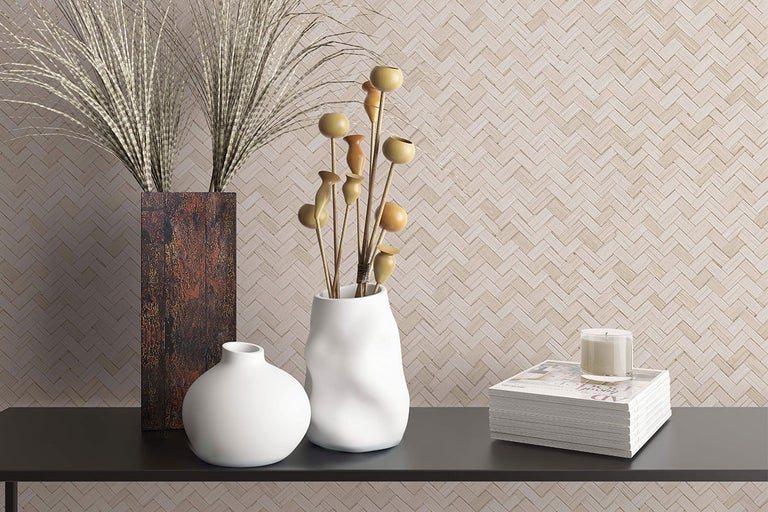 Decoratieve scène met vazen, droogbloemen, tijdschriften en kaars op een tafel.