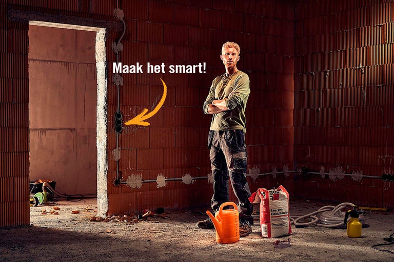 Ruwe bouwkamer met elektricien en elektriciteitsmaterialen