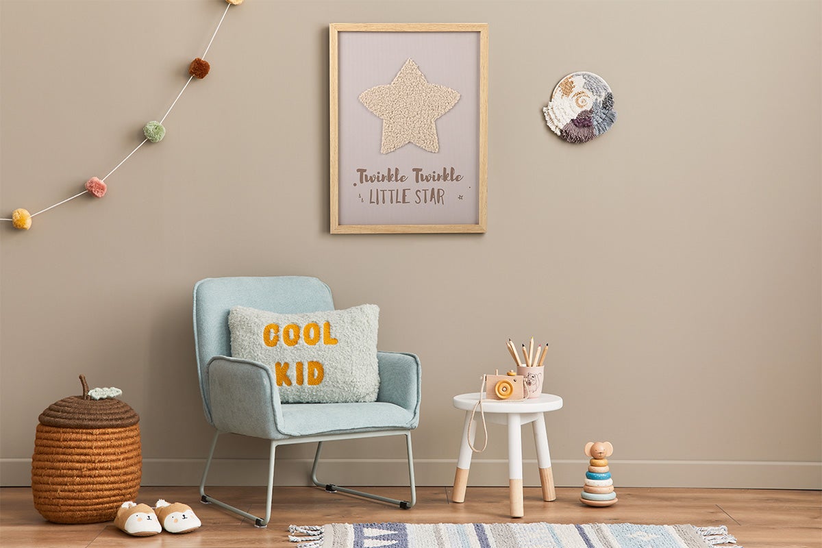 Gedecoreerde kinderkamer met stoel, bijzettafel en wanddecoratie