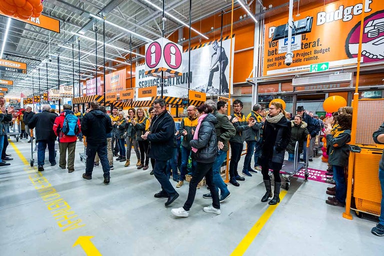 Een menigte mensen staat in een Hornbach bouwmarkt en klapt in hun handen.