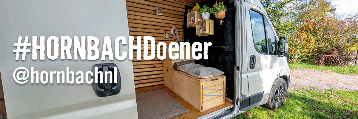 Interieur van een omgebouwde bestelwagen met houten afwerking en bed