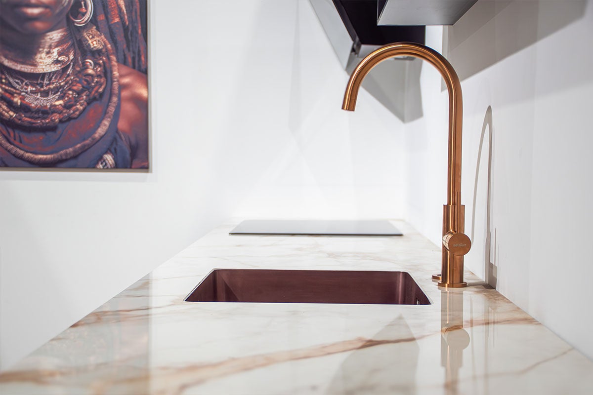 Keukenscène met spoelbak, kraan en kookplaat op een marmeren aanrechtblad