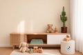 Een kinderkamer met een houten dressoir, gedecoreerd met boeken, een teddybeer, een cactus, speelgoedfiguren en een houten treintje.