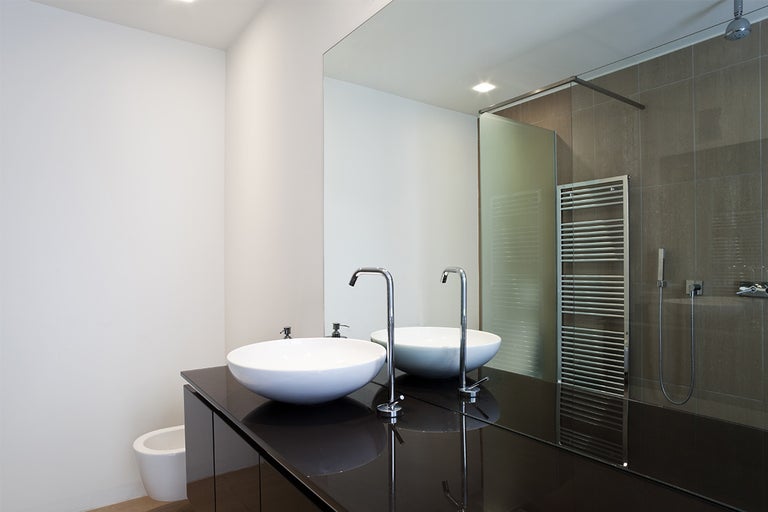 Moderne badkamer met dubbele wastafel, opzetwastafel en grote spiegel