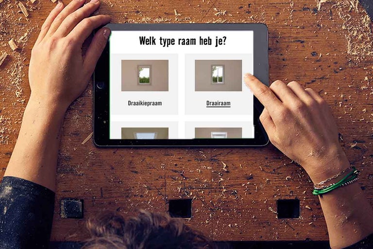 Een persoon gebruikt een tablet om op Hornbach naar het juiste raam te zoeken.