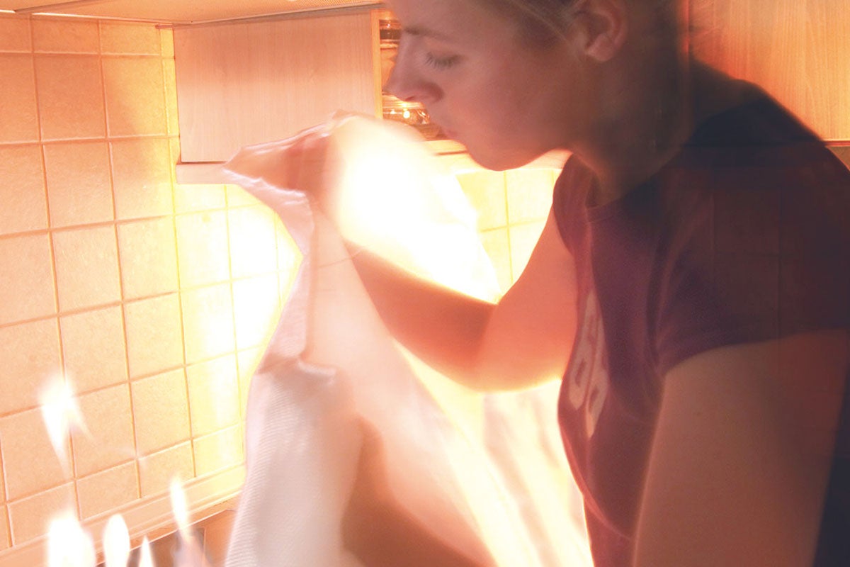 Een persoon blaast in een transparante zak in een keuken.