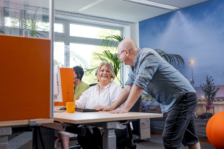 Kantoor scène met medewerkers aan bureaus die aan computers werken