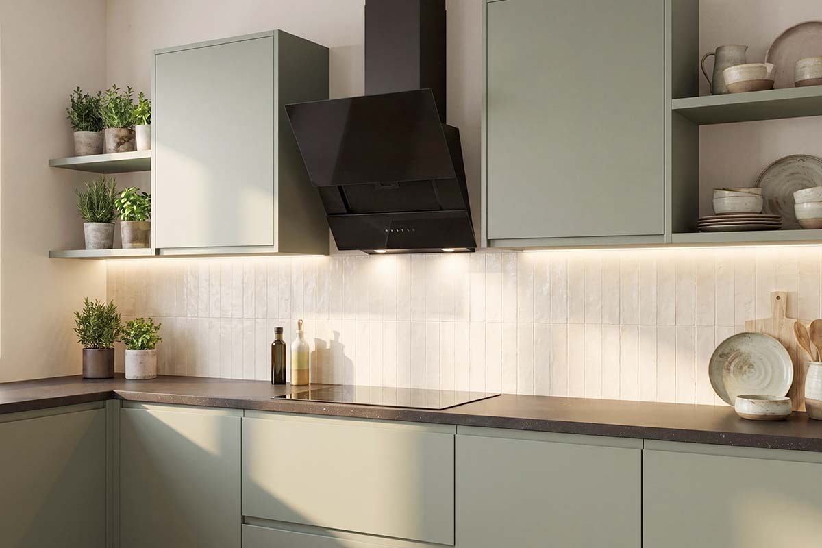 Moderne keuken met groene fronten, donker werkblad, zwarte schuine afzuigkap en ingebouwde ledverlichting.
