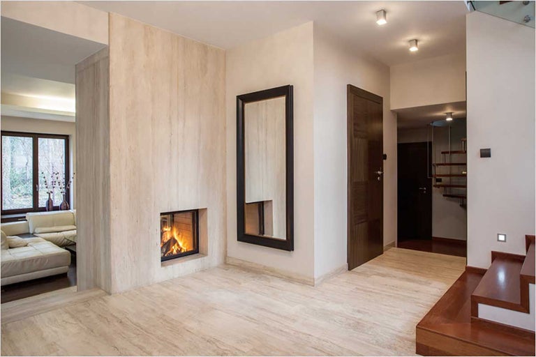 Interieur met open haard, spiegel, deur en trap.