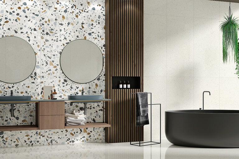 Moderne badkamer met terrazzo tegels op wand en vloer, dubbele wastafel en vrijstaand bad