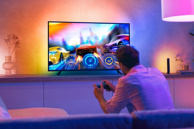 Man speelt racespel op televisie in de woonkamer