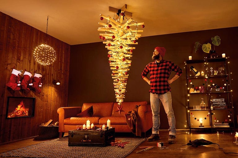Woonkamer met hangende houten kerstboom, versierd met lichtjes en ballen