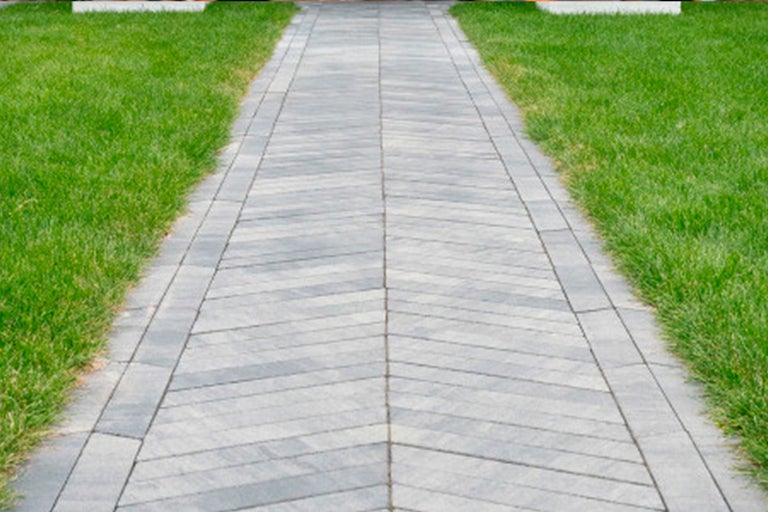 Bestraat tuinpad met gazons