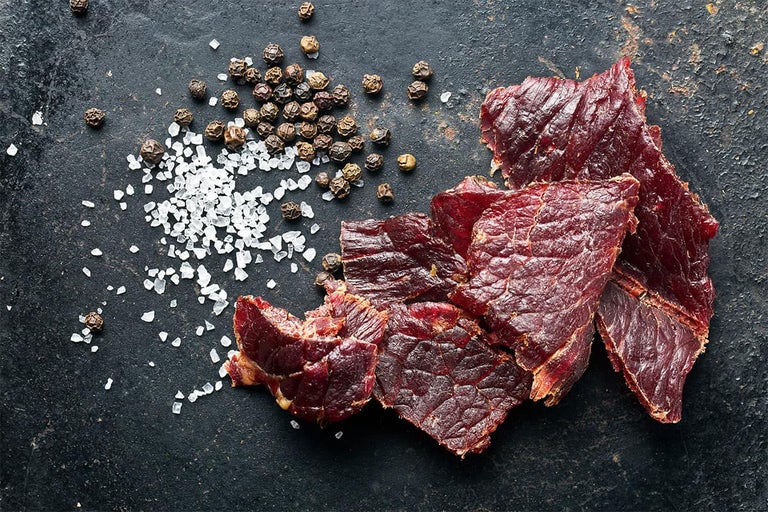 Close-up van gedroogd vlees met zout en peperkorrels