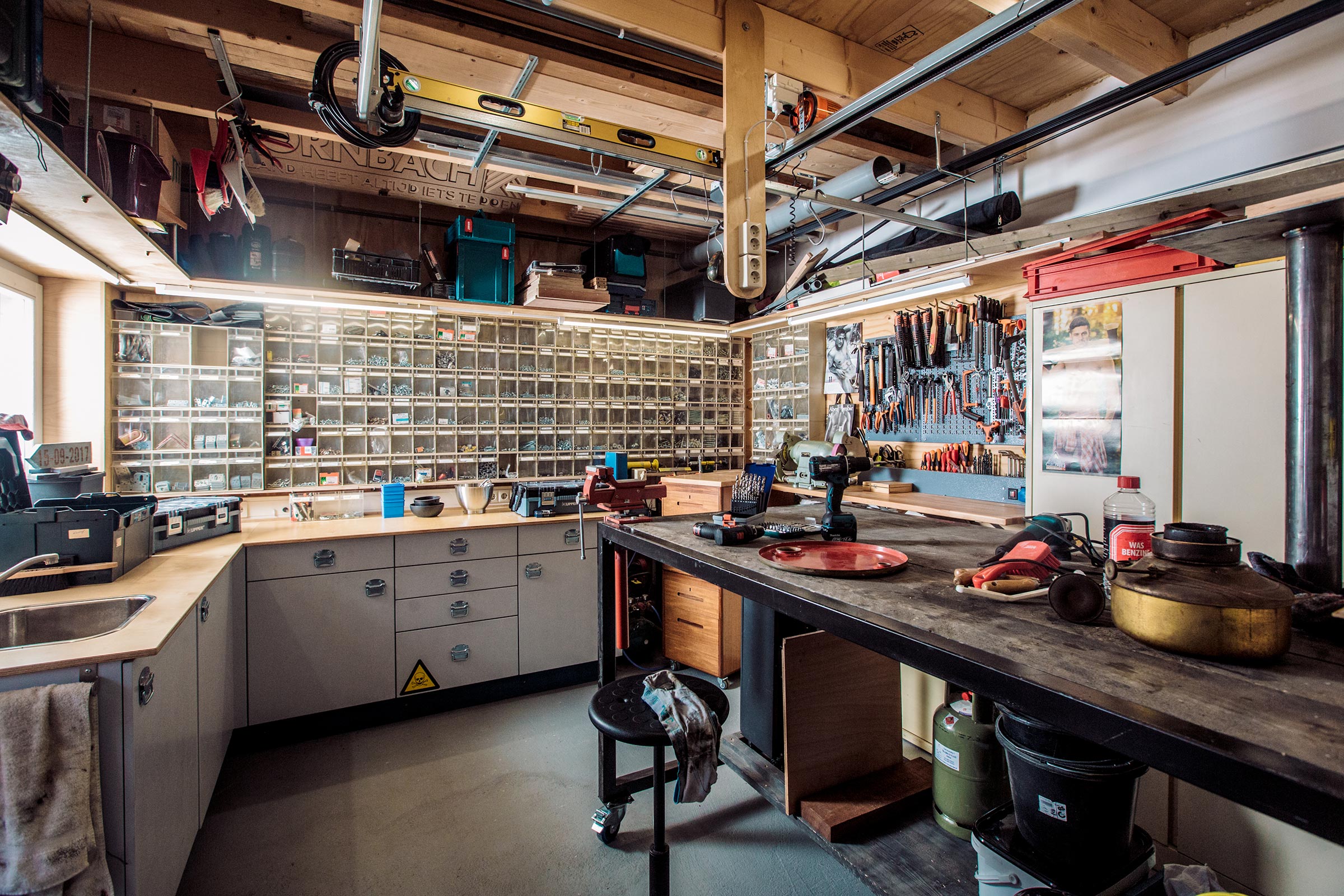 Werkplaats met werkbank, gereedschapswand, gereedschapskasten en diverse gereedschappen