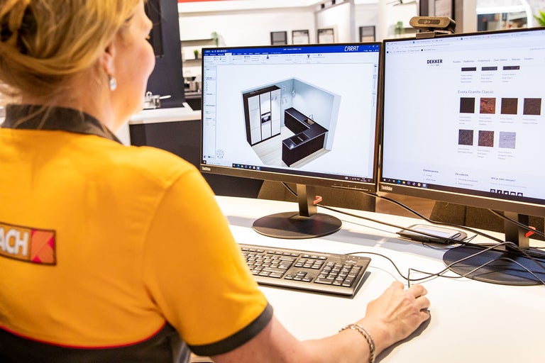 Een vrouw plant een keuken op de computer bij Hornbach.