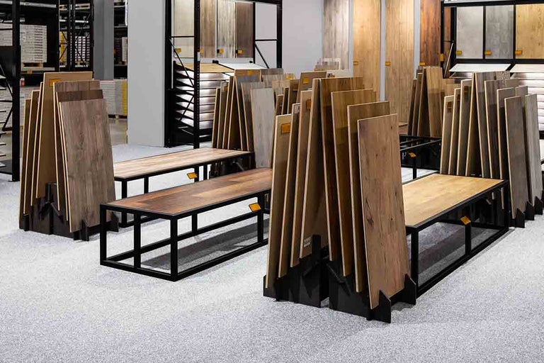 Tentoonstelling van laminaatvloeren op banken in een bouwmarkt.