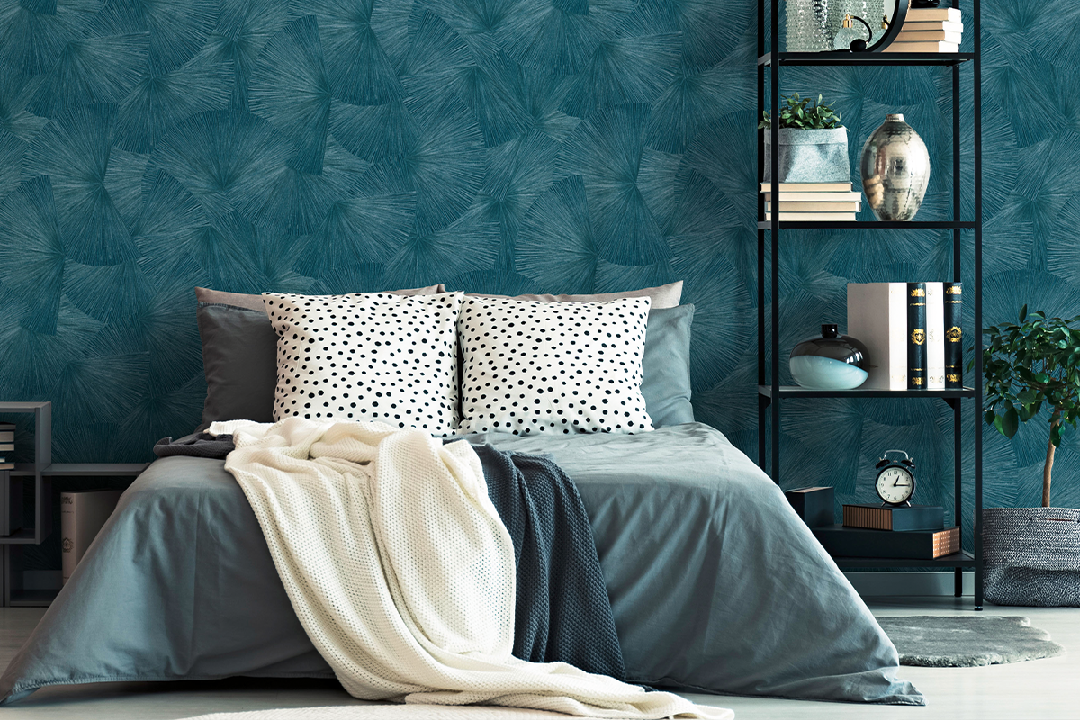 Moderne slaapkamer met behang met waaierstructuur, bed met gestippelde kussens en gebreide deken en een smalle metalen stellingkast.