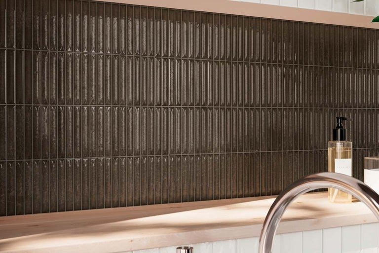 Smalle wandtegels in verticale opstelling als keukenachterwand boven een houten werkblad.