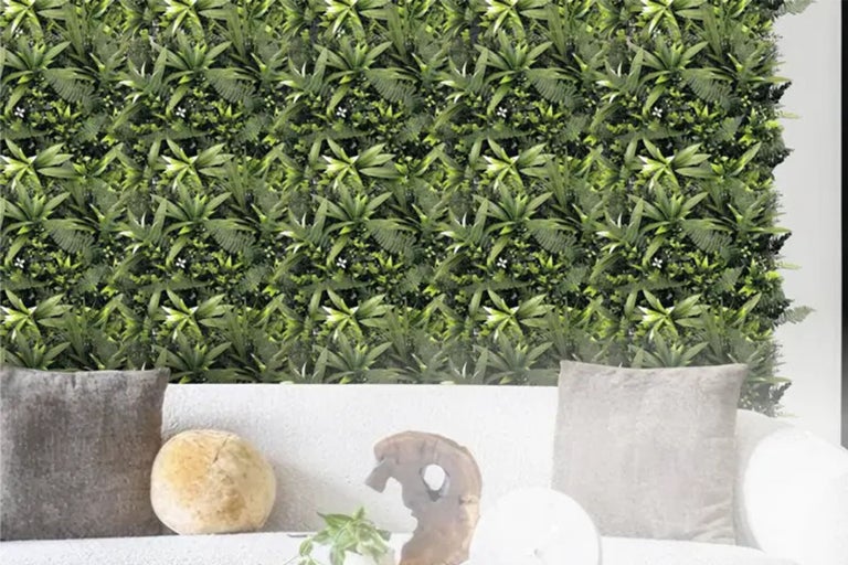 Woonkamer met groene plantenwand en bank
