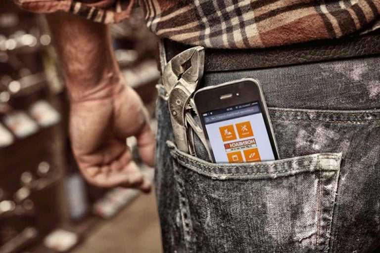 Persoon met mobiele telefoon en tang in de zak