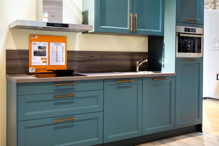 Keuken met spoelbak, kookplaat, afzuigkap en ingebouwde oven.