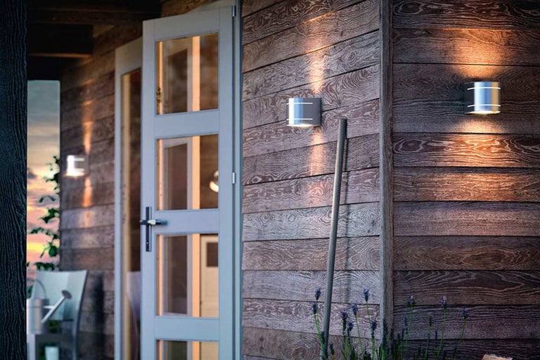 Houten gevel met buitendeur en twee buitenlampen
