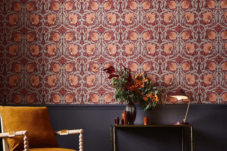 Decoratieve kamer met bloemenbehang, fauteuil, tafel met bloemenvaas en tafellamp.