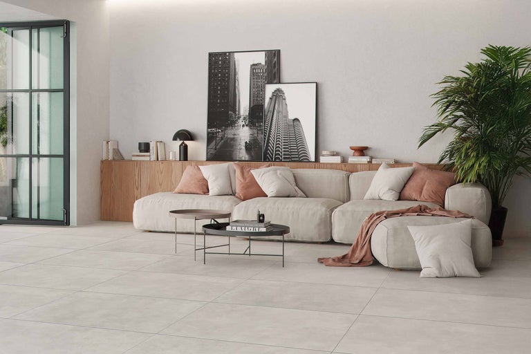 Lichte woonkamer met bank, salontafel, kamerplant en vloertegels