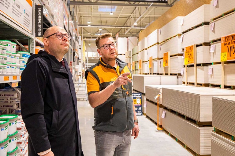 Twee mannen staan voor een schap met gipsplaten in de Hornbach bouwmarkt.