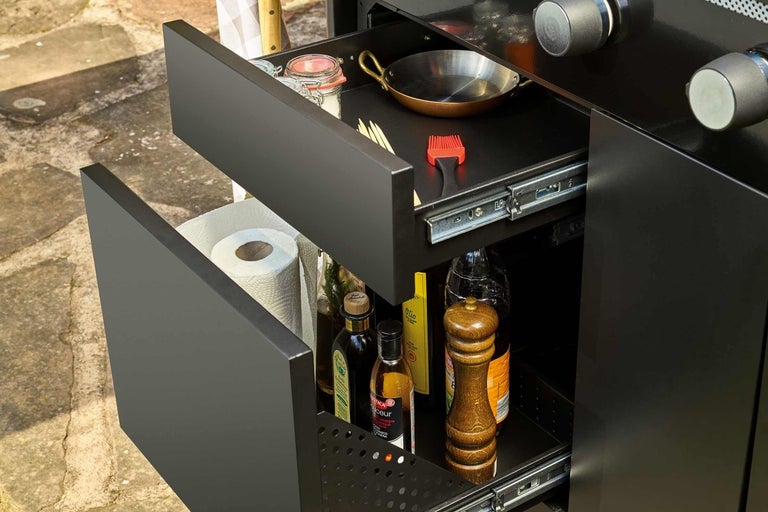 Lades van een buitenkeuken met kookgerei en ingrediënten