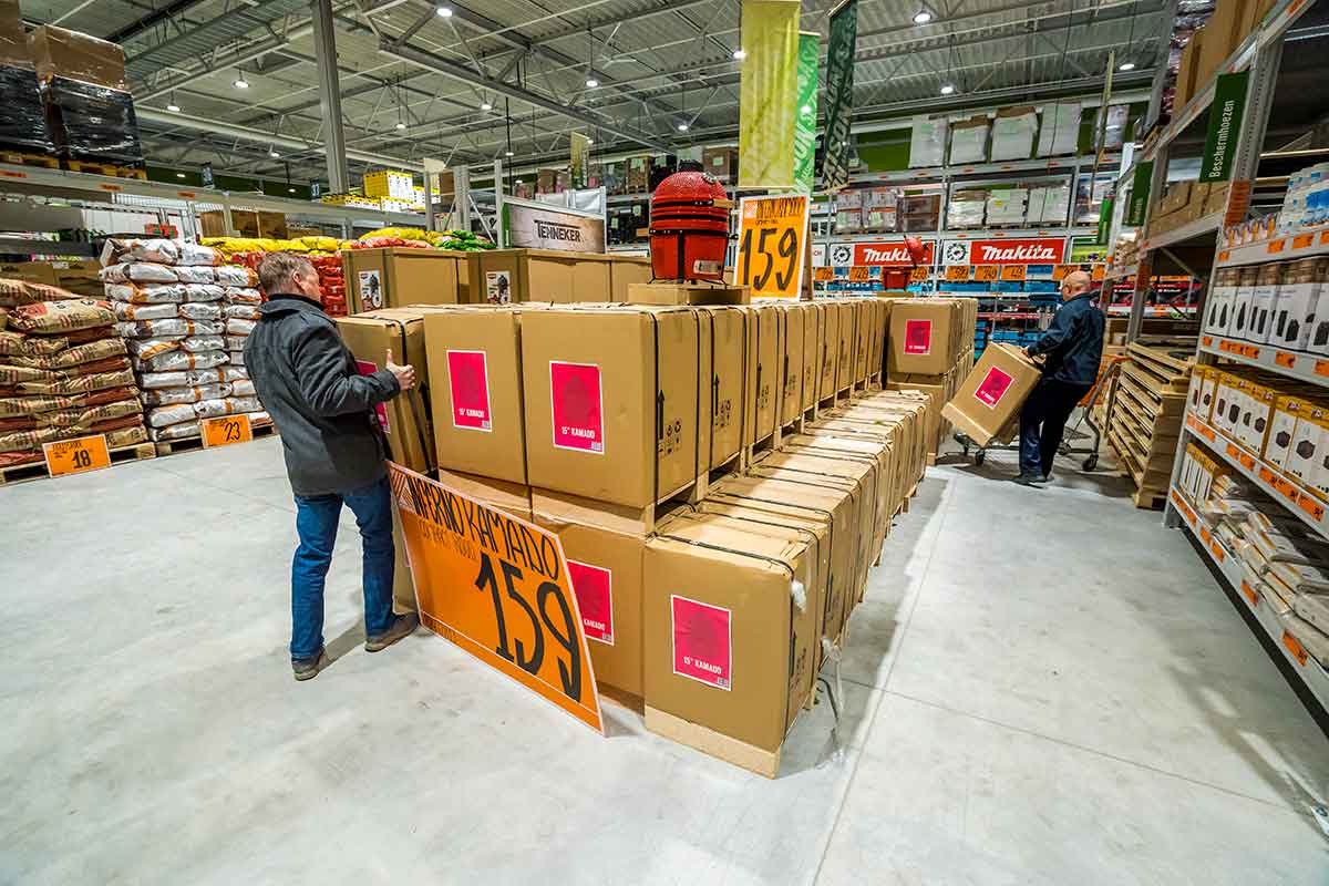 In een Hornbach-bouwmarkt staan medewerkers voor een rij verpakte grills en bereiden deze voor de verkoop voor.